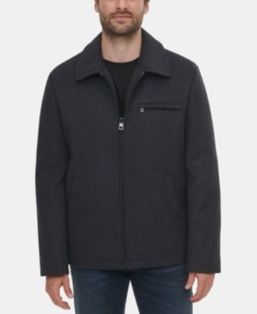 Translation missing: en.A man wearing a dark charcoal gray zip-up jacket with a stand-up collar and a chest pocket, paired with a black shirt and blue jeans, against a plain light gray background