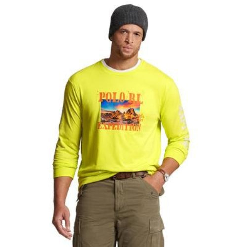 Translation missing: en.A man wearing a bright neon yellow long-sleeve Polo Ralph Lauren shirt with a desert landscape graphic on the chest, paired with olive cargo pants and a dark gray beanie, against a plain white background