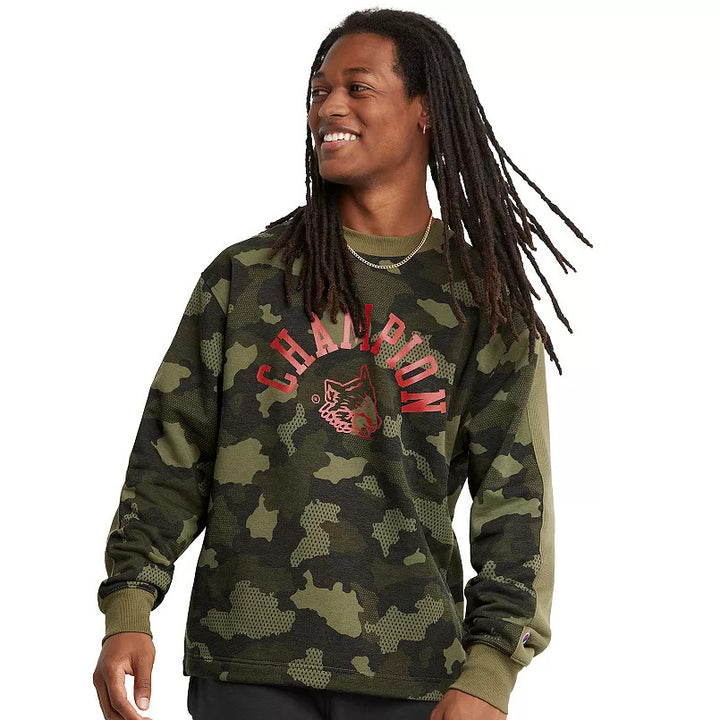 Translation missing: en.A smiling man with long dreadlocks wearing a green camouflage Champion sweatshirt with red 'CHAMPION' text and a red wolf logo on the chest, photographed against a plain white background