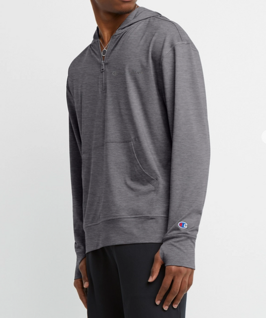 Translation missing: en.A man wearing a heather gray Champion half-zip hoodie with a small embroidered Champion logo on the left sleeve cuff, paired with black pants, against a plain light gray background